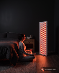 Revival Panel Flare red light therapy panel, lifestyle in-use shot, warm ember glow at night