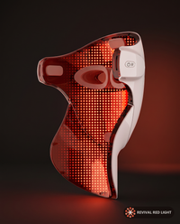 Revival Halo LED face and neck therapy mask, interior LED array visible, 3/4 angle, powered on with warm ember glow