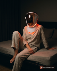 Revival Halo LED face and neck therapy mask, candid lifestyle in-use shot, warm ember glow