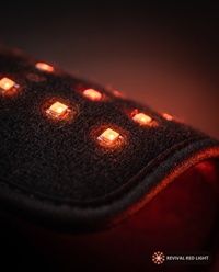 Revival Wrap red light therapy pad, LED close-up detail, powered on with warm ember glow