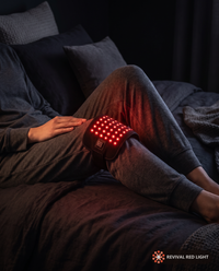 Revival Wrap red light therapy pad, lifestyle in-use shot, warm ember glow at night
